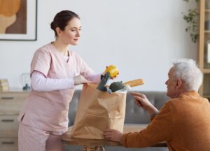 young nurse bringing groceries to senior man 2025 03 08 01 59 34 utc